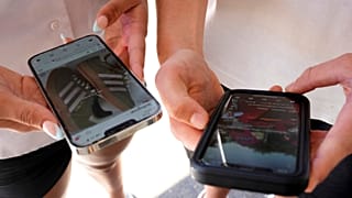 FILE - Young people use their phones to view social media in Sydney, Nov. 8, 2024.