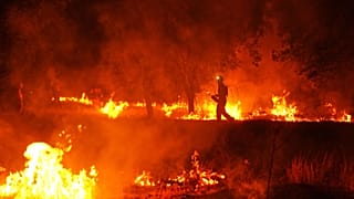 Firefighters use controlled burning to halt a wildfire that continues to spread near Cebreros, Ávila province, Spain, 28 July 2026