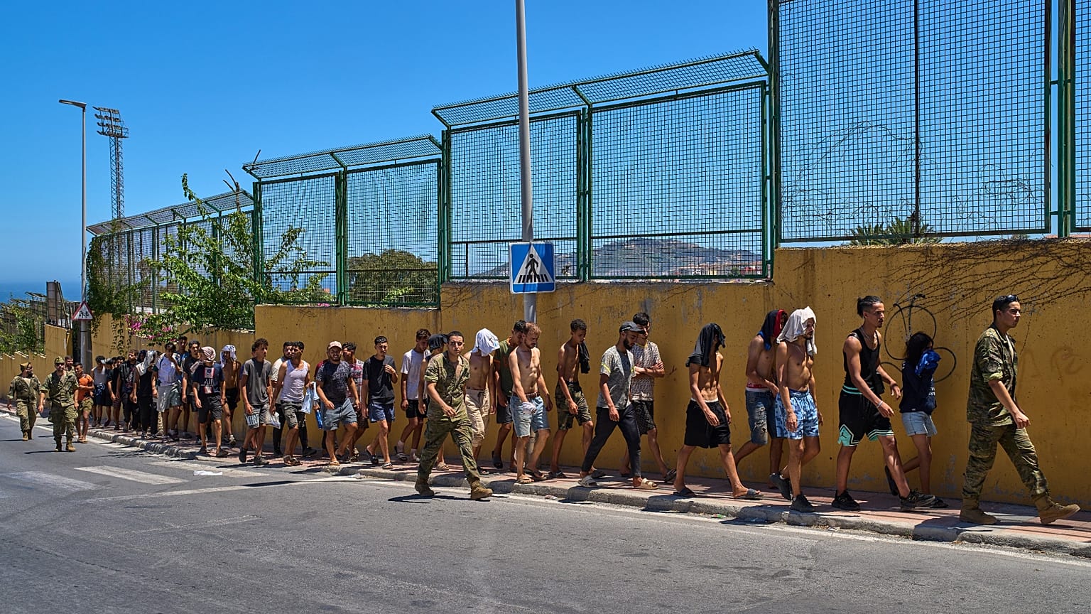 Migrants who crossed into Ceuta are escorted by Spanish soldiers toward the Spanish-Moroccan border for their return to Morocco from the Spanish enclave, Sunday, Aug.2,2026