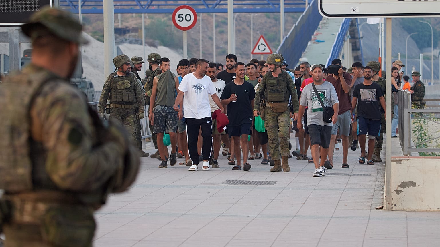 Escorted by the Spanish army, migrants who crossed into Spain return to Morocco from the Spanish enclave of Ceuta on Saturday, Aug. 1, 2026.