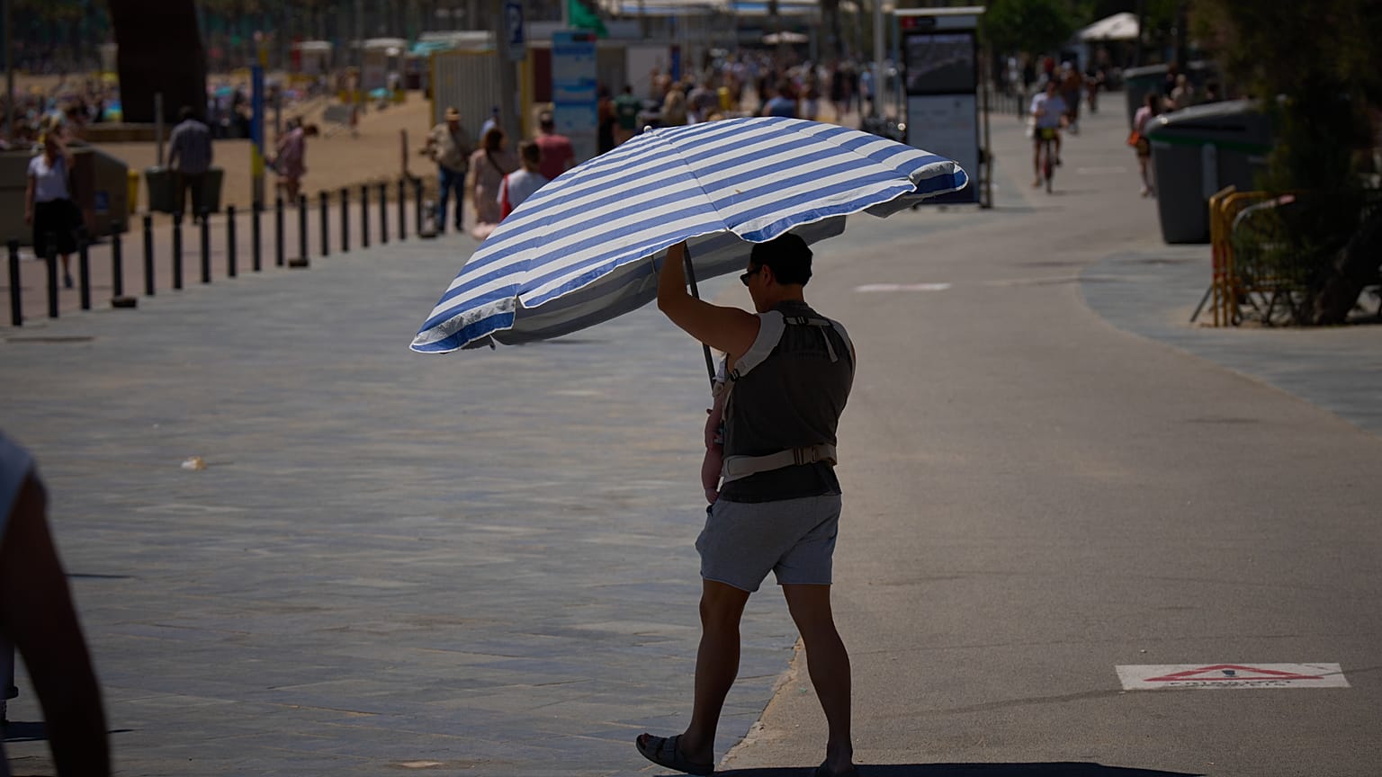 A man holds an umbrella as he walks near a beach in Barcelona, Spain, on Wednesday 27 May 2026.