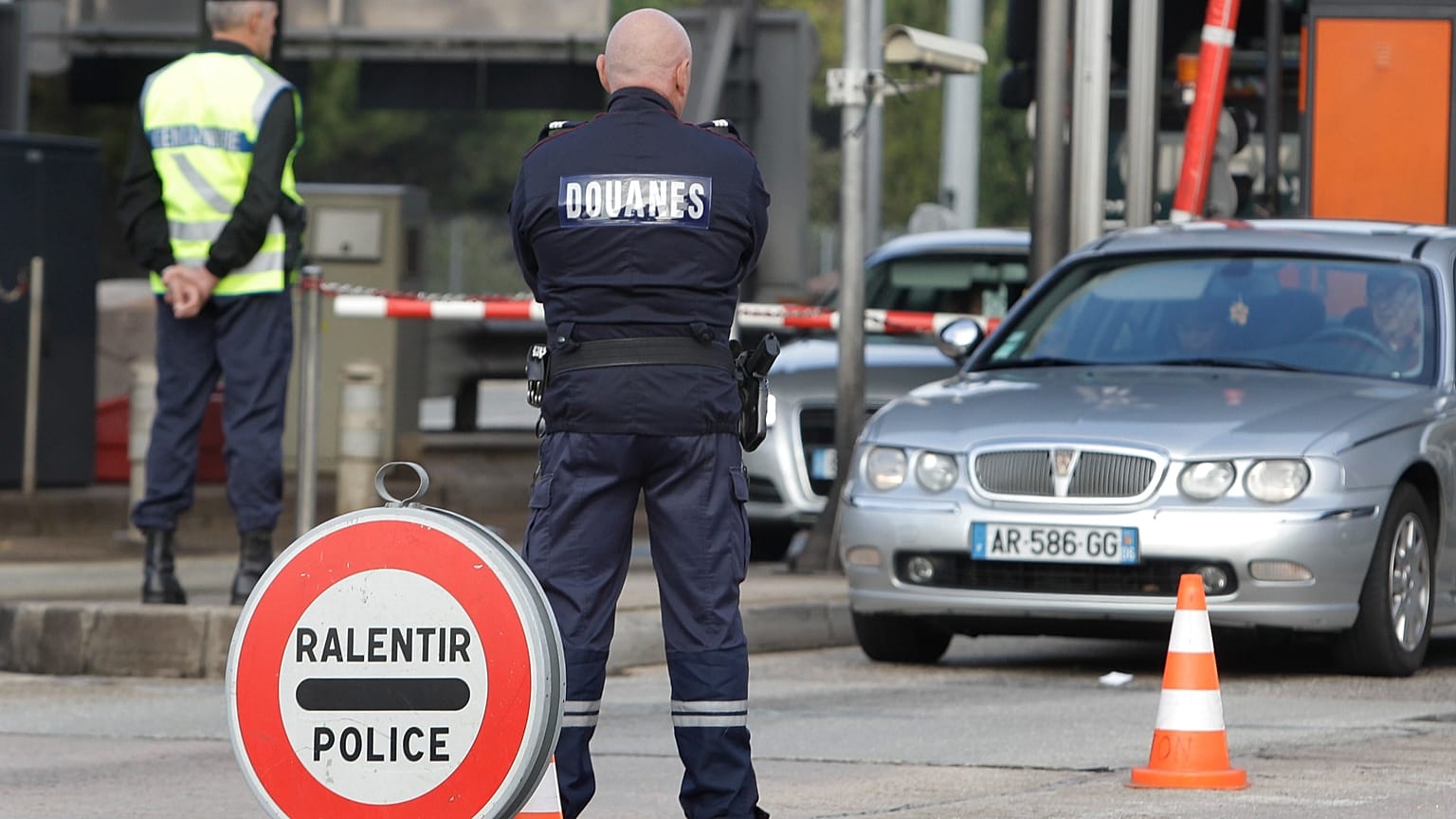  In this Monday, Oct. 31, 2011 file photo, a French gendarme and French custom officer check vehicles, in La Turbie, southeastern France, near the Franco-Italian border