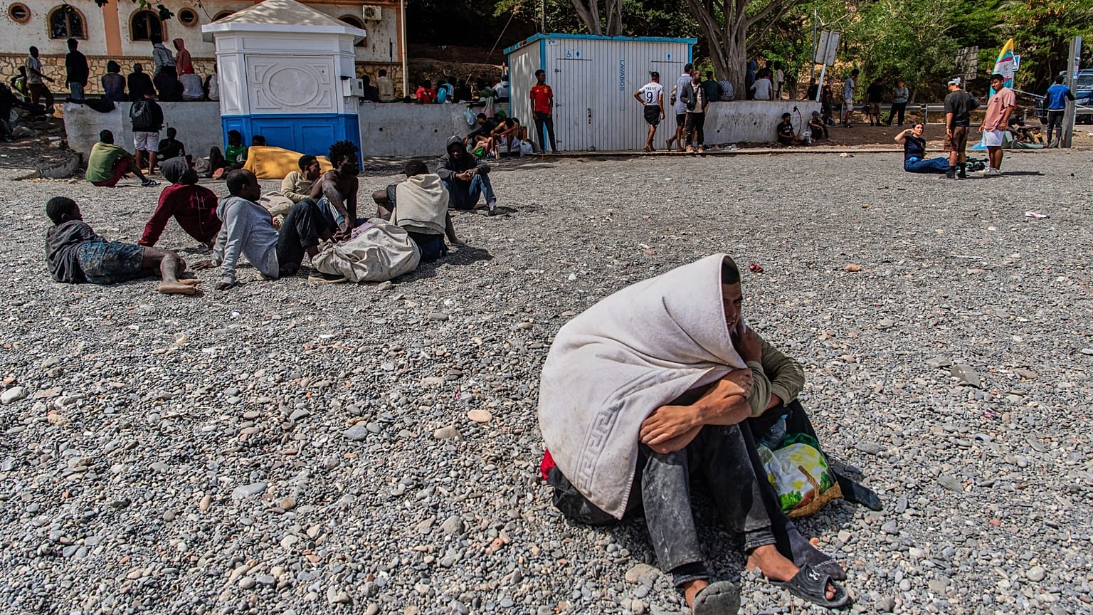 Migrants who have crossed into Spain from Morocco gather on a beach in the Spanish enclave of Ceuta on Monday 3 August 2026.