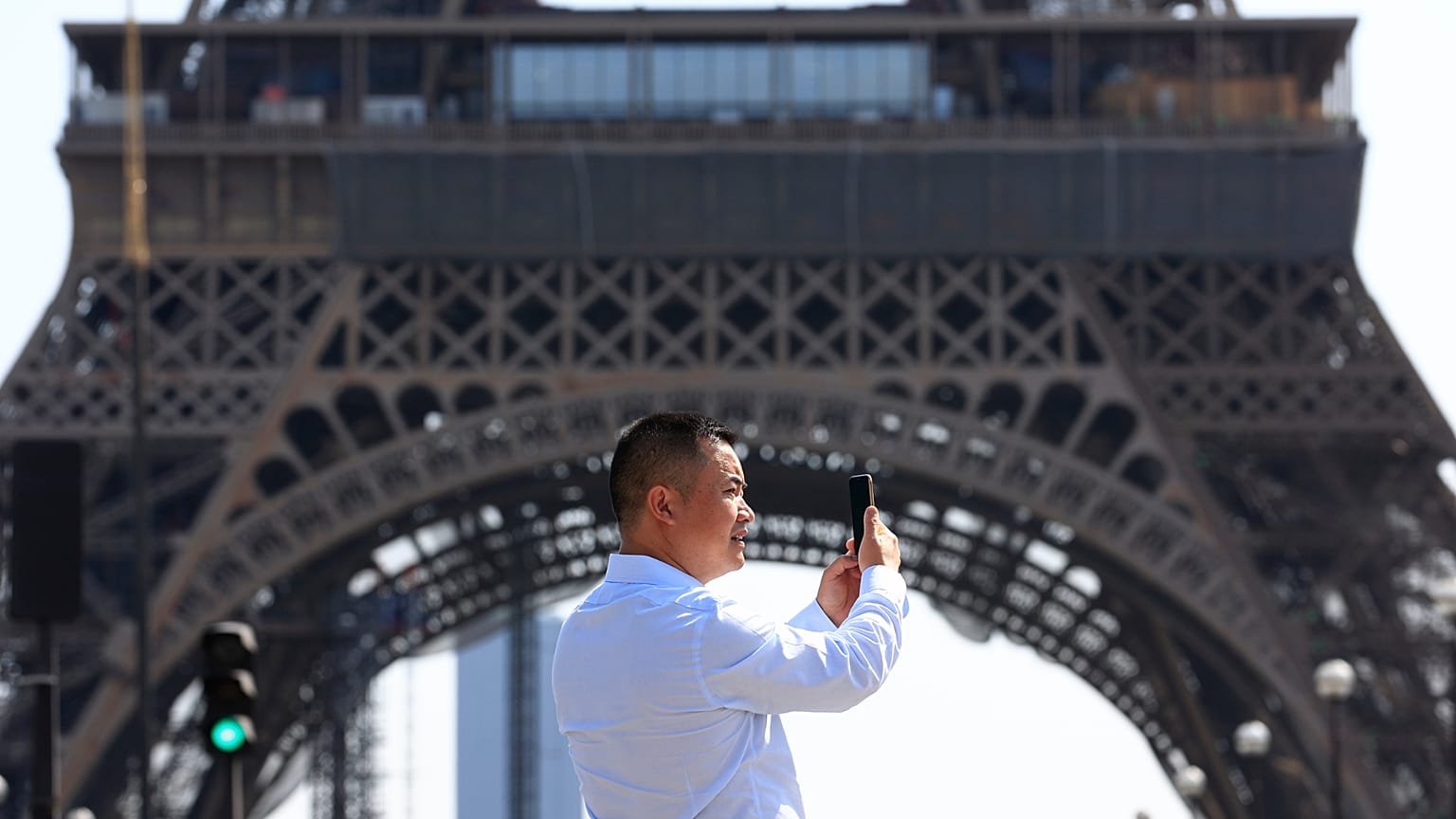 A person uses their phone near the Eiffel Tower in Paris on Wednesday 31 August 2022.