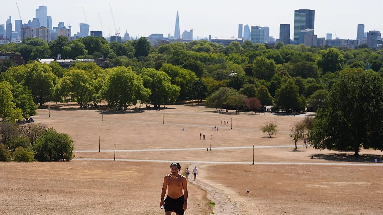 A person walking through Primrose Hill, as temperatures are expected to reach up to 33 °C in parts of the UK, in north London Sunday, Aug. 9, 2026.