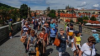 A pack of tourists walk during a guided tour in Prague, Czech Republic, Wednesday, July 5, 2023. 
